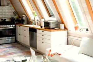 Dapur modern rumah luas di Jakarta Selatan dengan kitchen set putih dan pencahayaan alami atap miring
