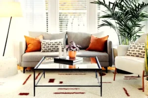 Ruang tamu rumah luas Jakarta Selatan dengan sofa abu-abu dan tanaman hias interior modern
